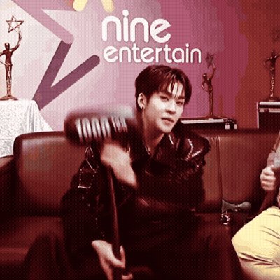 Man Sitting On Couch In Front Of Nine Entertain Sign GIF
