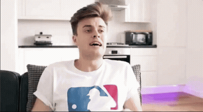 Man Sitting On Couch In White Baseball T-Shirt GIF
