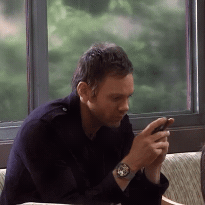 Man Sitting On Couch Looking At Phone GIF