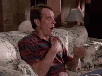 Man Sitting On Couch Mouth Open Hands On Chest GIF