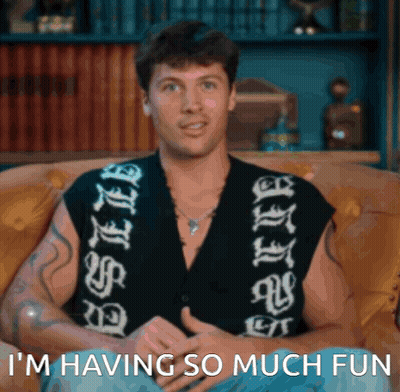 Man Sitting On Couch Saying I'm Having So Much Fun GIF
