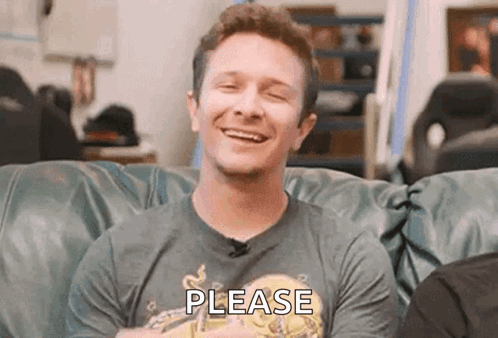 Man Sitting On Couch Smiling Wearing Shirt Please GIF