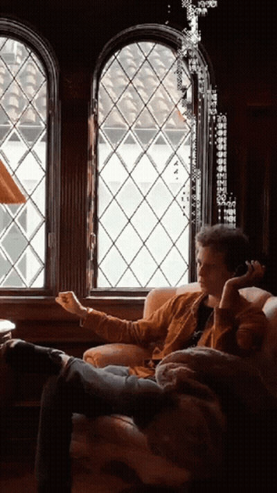 Man Sitting On Couch Talking On Cell Phone GIF