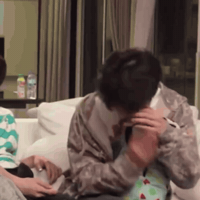 Man Sitting On Couch Talking On Cell Phone Holding Baby GIF