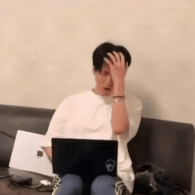 Man Sitting On Couch Using Laptop Holding His Head GIF