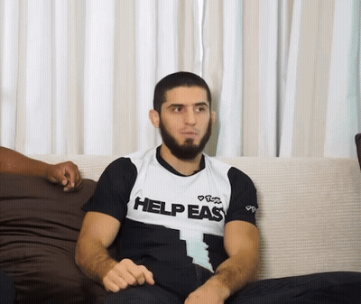 Man Sitting On Couch Wearing Help Easy Shirt GIF