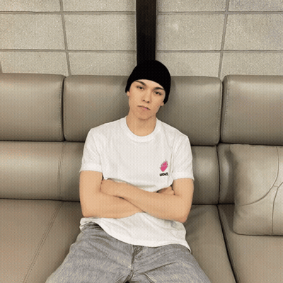 Man Sitting On Couch With Arms Crossed Wearing IDC T-Shirt GIF