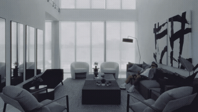 Man Sitting On Couch With Chairs And Coffee Table GIF