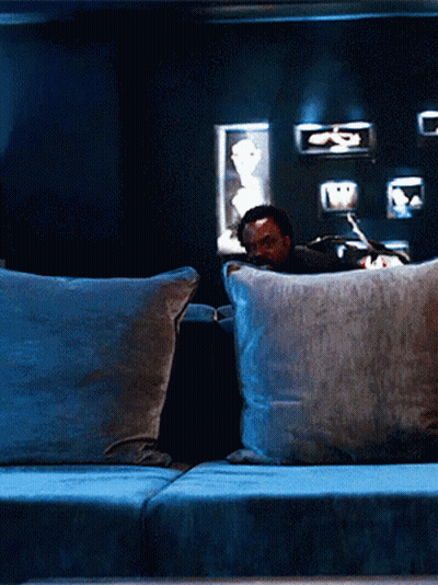 Man Sitting On Couch With Two Pillows GIF