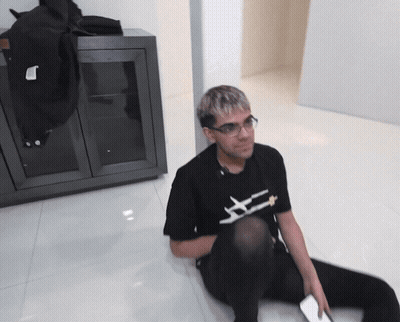 Man Sitting On Floor In Black Shirt Saying X GIF