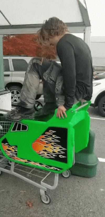 Man Sitting On Green Shopping Cart With Flames GIF