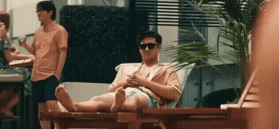 Man Sitting On Lawn Chair Looking At Phone GIF