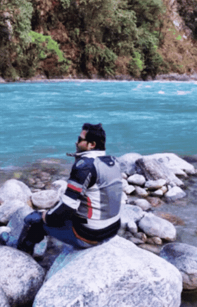 Man Sitting On Rock Near River GIF
