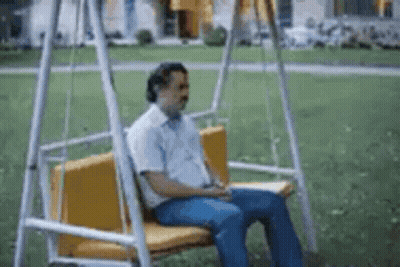 Man Sitting On Swing With Eyes Closed GIF