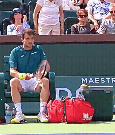 Man Sitting On Tennis Court Holding Racquet GIF