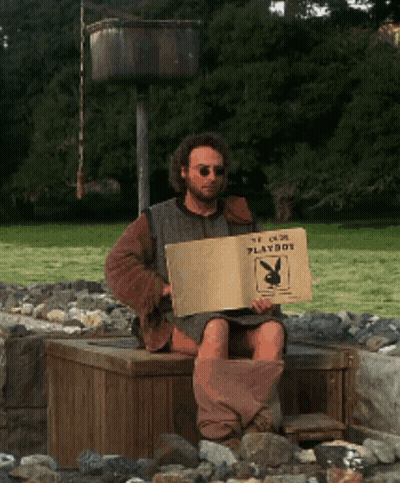 Man Sitting On Wooden Box Holding Playboy Sign GIF