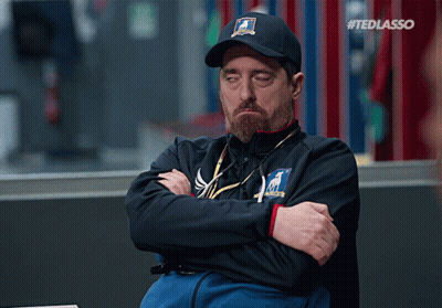 Man Sitting With Arms Crossed Wearing Ted Lasso Hat GIF