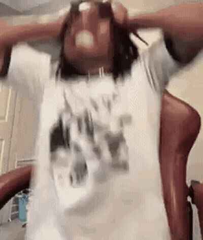 Man Sitting With Arms Outstretched And Hands On Head GIF