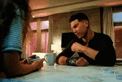 Man Sitting With Coffee And Woman Holding Phone GIF