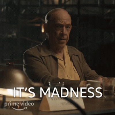 Man Sitting With Coffee Behind Madness GIF