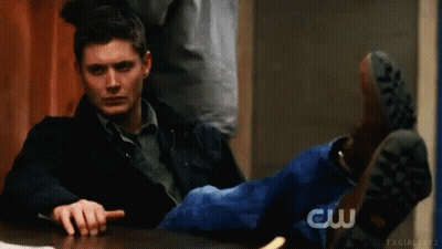 Man Sitting With Feet Up Pointing At Camera GIF