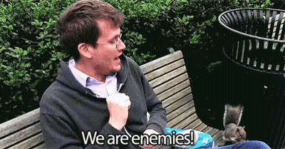 Man Sitting With Squirrel Saying We Are Enemies GIF