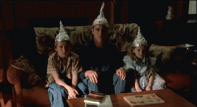 Man Sitting With Two Children In Tin Foil Hats GIF