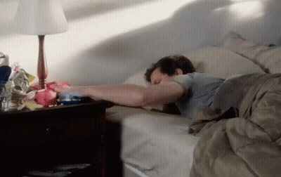 Man Sleeping In Bed Next To Lamp And Nightstand GIF