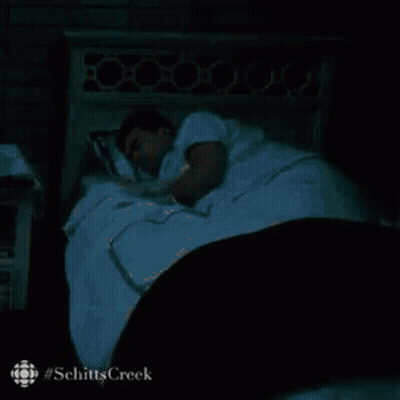 Man Sleeping In Bed With White Blanket And Black Comforter GIF