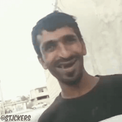 Man Smiling And Looking At Camera In Front Of Wall GIF