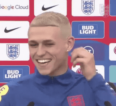Man Smiling At Microphone In Front Of Bud Light Sign GIF