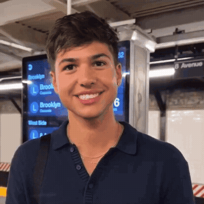 Man Smiling In Front Of 8 Avenue Sign GIF