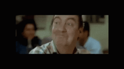 Man Smiling In Front Of Bravo Biloute Sign GIF