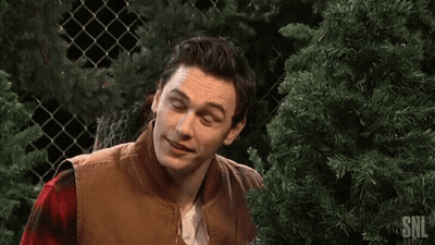 Man Smiling In Front Of Christmas Tree GIF
