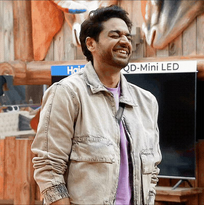 Man Smiling In Front Of Haier Ad GIF
