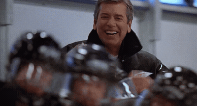 Man Smiling in Front of Hockey Players