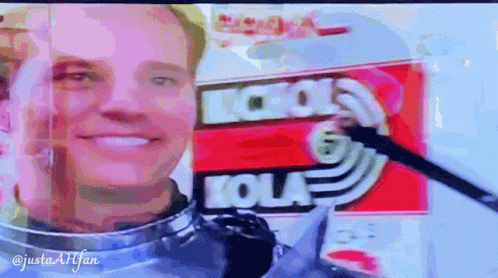 Man Smiling In Front Of Kola Sign GIF