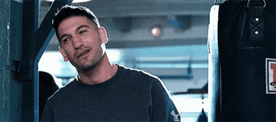 Man Smiling In Front Of Punching Bag GIF