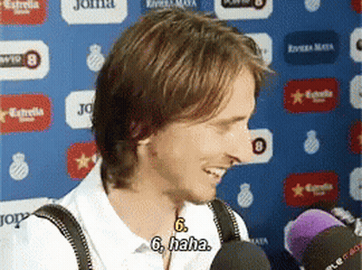 Man Smiling Talking Into Microphone Wearing Suspenders GIF