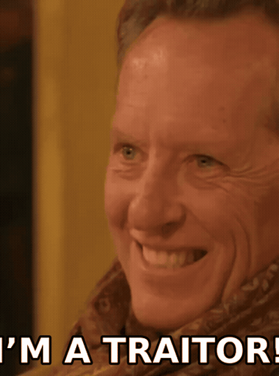 Man Smiling With I'm A Traitor Behind Him GIF