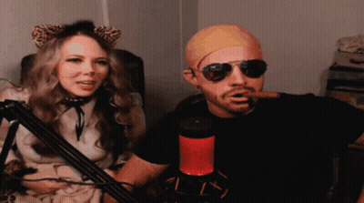 Man Smoking Cigar Next To Woman With Cat Ears And Sunglasses GIF