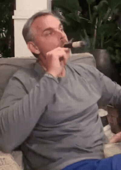 Man Smoking Cigar On Couch GIF