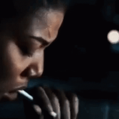 Man Smoking Cigarette In Front Of Pumpkin With Candle GIF