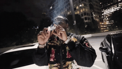 Man Smoking Cigarette In Parking Lot At Night GIF