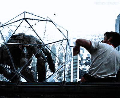 Man Smoking Cigarette Looking At Spider In Glass Cage GIF