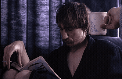 Man Smoking Cigarette Reading Book With Letter O GIF
