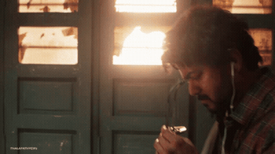 Man Smoking Cigarette With Ear Buds GIF
