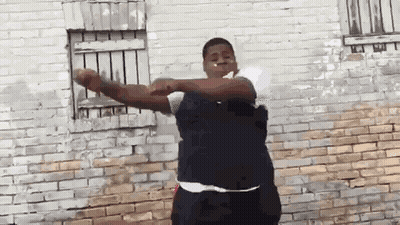 Man Smoking In Front Of Brick Wall GIF