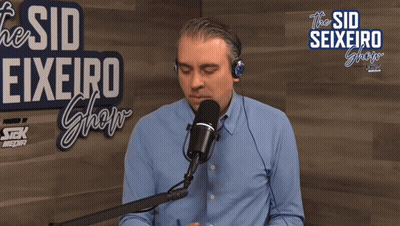 Man Speaking Into Microphone At The Sid Seixeiro Show Sign GIF