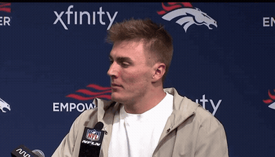 Man Speaking Into Microphone In Front Of Empower Banner GIF
